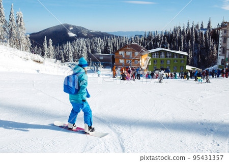 Girl in winter clothes drinking tea on the background of snow-capped mountains on the sunny day. Girl in winter clothes drinking tea on the background of snow-capped mountains on the sunny day. 95431357