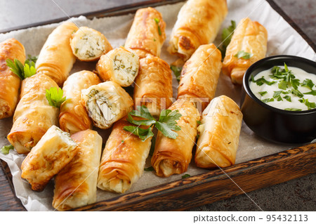 Sigara boregi Turkish snacks made from phyllo pastry, stuffed with feta cheese closeup on the wooden board. Horizontal Sigara boregi Turkish snacks made from phyllo pastry, stuffed with feta cheese closeup on the wooden board. Horizontal 95432113