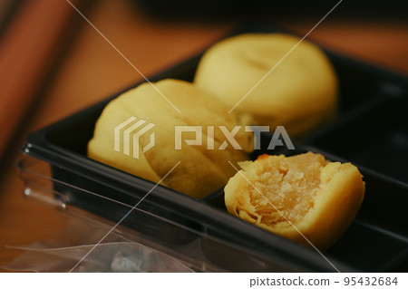 Chinese pastry with egg yolk, Chinese traditional dessert made from bean mixed egg yolk on plate, close up shot horizontal view. 95432684