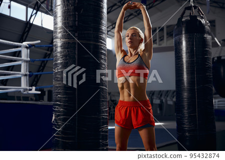 Sportive woman, female professional boxer training at sports gym, indoors. Sport, action, power, energy concept. Women in sport 95432874
