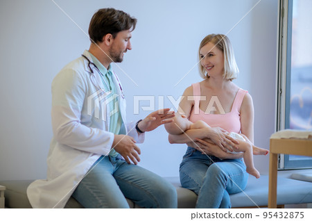 Pediatric doctor receiving patients in his office 95432875