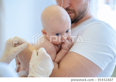 Pediatrician conducting a medical procedure on the child 95432887