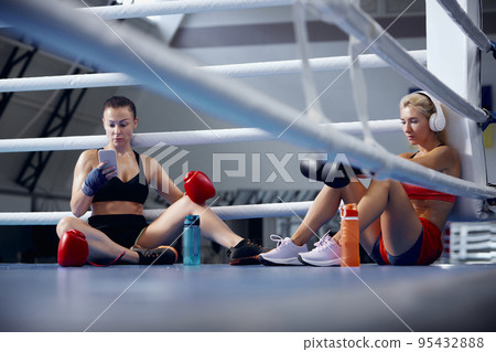 Young female athletes, professional boxers, kickboxers have a rest after hard training at sports gym. Concept of sport, workout, active and healthy lifestyle 95432888