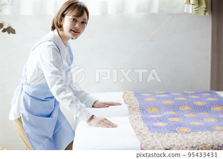 Cute woman making a bed 95433431