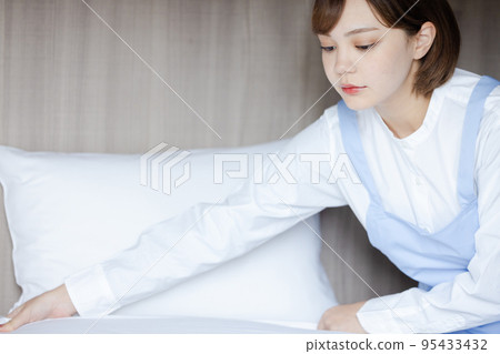 Cute woman making a bed 95433432