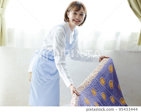 Cute woman making a bed 95433444