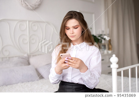 A young business woman reads the news or sends a text message 95435869