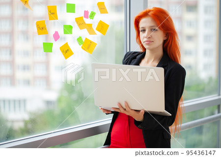 Beautiful joyful woman smiling while working with laptop in office Beautiful joyful woman smiling while working with laptop in office 95436147