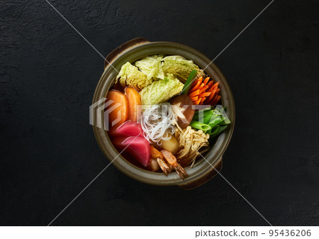 Traditional Japanese sea food sumo stew foods with shiitake mushrooms, tuna, salmon and vegatables. Asian culture style food. Top view. Hot tasty soup on black background Traditional Japanese sea food sumo stew foods with shiitake mushrooms, tuna, salmon and vegatables. Asian culture style food. Top view. Hot tasty soup on black background 95436206