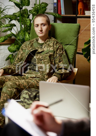 Psychologist conducts treatment, conversation with young girl, former military man in office, indoors. Concept of mental health, post-traumatic syndrome 95436458