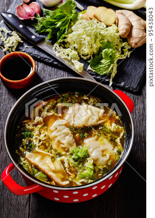Asian Potsticker Soup in red pot, top view 95438043