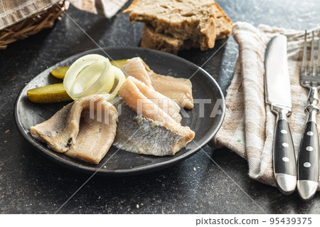 Marinated herring fish on plate. 95439375