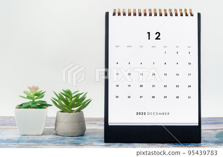 The December 2022 Monthly desk calendar for 2022 year with plant pot on old blue wooden background 95439783