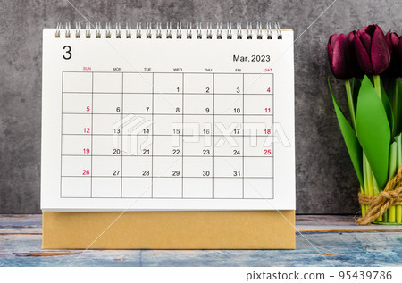 The March 2023 Desk calendar for 2023 year with flower on wooden background. 95439786