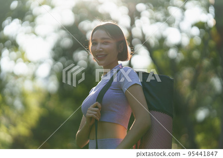 Attractive Asian woman in sportswear practicing yoga in the outdoor park 95441847