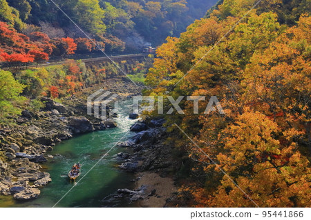 A trolley train (Kyoto Sagano) runs through Hozukyo Gorge A trolley train (Kyoto Sagano) runs through Hozukyo Gorge 95441866