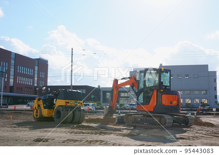 施工現場的振動壓路機和挖掘機 95443083