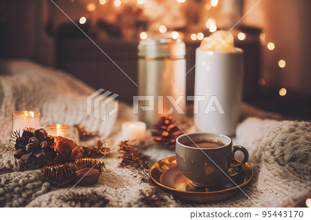 Cozy winter or autumn morning at home. Swedish hygge includes hot coffee with a gold metallic spoon Cozy winter or autumn morning at home. Swedish hygge includes hot coffee with a gold metallic spoon 95443170