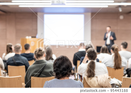 Speaker giving a talk in conference hall at business event. Rear view of unrecognizable people in audience at the conference hall. Business and entrepreneurship concept. 95443188