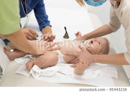 Baby beeing vaccinated by pediatrician in presence of his mother. Preventive vaccination against Diphtheria, whooping cough, tetanus, hepatitis, haemophilus influenzae, pneumococcus, poliomyelitis 95443236