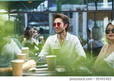 young asian adult friends gathering relaxing in outdoor coffee shop 95443483
