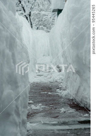 Snow tunnel for the passage of people made with a shovel. A lot of snow. Snowy winter in Europe. The global problems of climate change. Snow tunnel for the passage of people made with a shovel. A lot of snow. Snowy winter in Europe. The global problems of climate change. 95445265