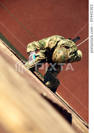 Special forces fighter descends from a skyscraper to storm the apartment. Police, counter terrorism concept. Mixed media 95445363