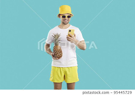 Happy man uses his mobile phone to order services or communicate with friends during summer vacation 95445729