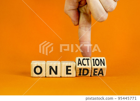 One idea and action symbol. Concept words One idea and One action on wooden cubes. Businessman hand. Beautiful orange table orange background. Business One idea and action concept. Copy space. One idea and action symbol. Concept words One idea and One action on wooden cubes. Businessman hand. Beautiful orange table orange background. Business One idea and action concept. Copy space. 95445771