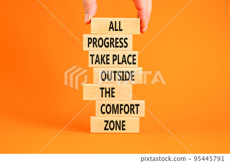 Progress symbol. Concept words All progress take place outside the comfort zone on wooden blocks on a beautiful orange background. Businessman hand. Business motivational and progress concept. Progress symbol. Concept words All progress take place outside the comfort zone on wooden blocks on a beautiful orange background. Businessman hand. Business motivational and progress concept. 95445791