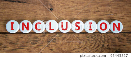 Symbol for a better inclusion. Wooden circles with word 'inclusion'. Beautiful wooden background. Copy space. Concept. 95445827