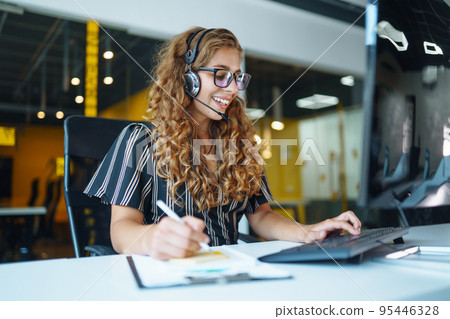 Meeting online. Young woman wearing headphones using laptop watching webinar or doing video chat. Meeting online. Young woman wearing headphones using laptop watching webinar or doing video chat. 95446328