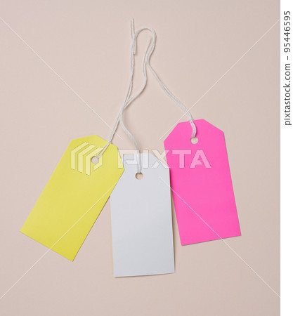 Set of empty white cardboard tag on a white rope, beige background. Price tag template 95446595