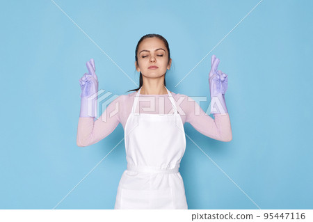 beautiful caucasian woman in gloves with finger crossed gesture 95447116