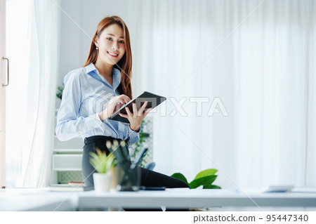Entrepreneurs, Business Owners, Accountants, Portrait of a Small Business Startup Asians showing happy smiling faces with tablets at work Entrepreneurs, Business Owners, Accountants, Portrait of a Small Business Startup Asians showing happy smiling faces with tablets at work 95447340