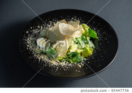 light caesar salad without meat on black plate on dark background light caesar salad without meat on black plate on dark background 95447736