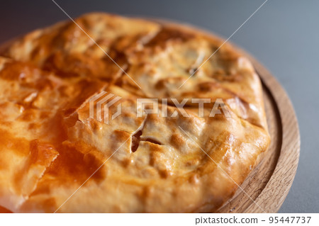 traditional georgian bread khachapuri on wooden board on black background traditional georgian bread khachapuri on wooden board on black background 95447737