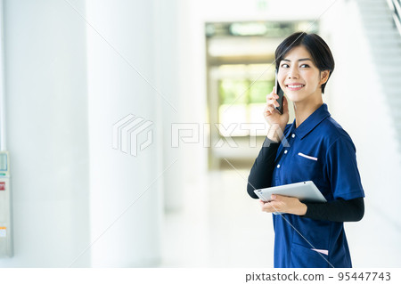 Caregiver operating a tablet Caregiver operating a tablet 95447743