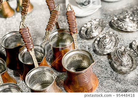 Several copper turks for making coffee are on table, top view at an angle of 45 degrees Several copper turks for making coffee are on table, top view at an angle of 45 degrees 95448418