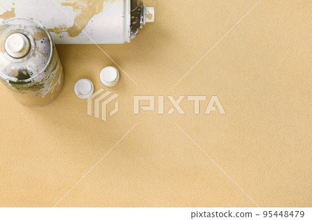 Some used orange aerosol spray cans and nozzles with paint drips lies on a blanket of soft and furry light orange fleece fabric. Classic fashion design color. Graffiti hooliganism concept Some used orange aerosol spray cans and nozzles with paint drips lies on a blanket of soft and furry light orange fleece fabric. Classic fashion design color. Graffiti hooliganism concept 95448479