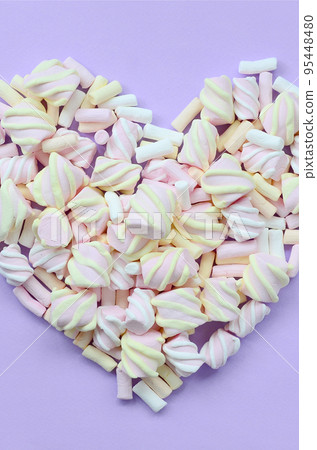 Colorful marshmallow laid out on violet and pink paper background. pastel creative textured heart. minimal Colorful marshmallow laid out on violet and pink paper background. pastel creative textured heart. minimal 95448480