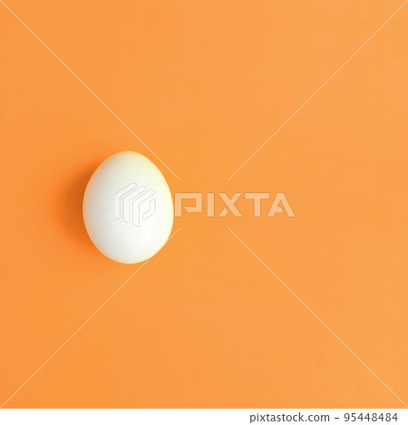 One white easter egg on a bright orange background One white easter egg on a bright orange background 95448484