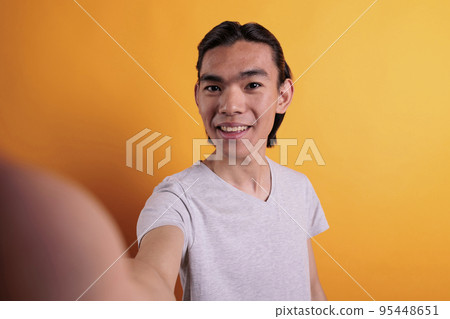 Smiling young asian man chatting on video call fpv. Remote communication pov, teenager attending webinar, attractive cheerful person talking on online meeting first person view Smiling young asian man chatting on video call fpv. Remote communication pov, teenager attending webinar, attractive cheerful person talking on online meeting first person view 95448651