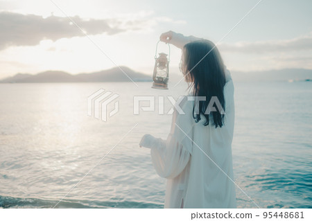Photo of a woman standing by the beach Photo of a woman standing by the beach 95448681