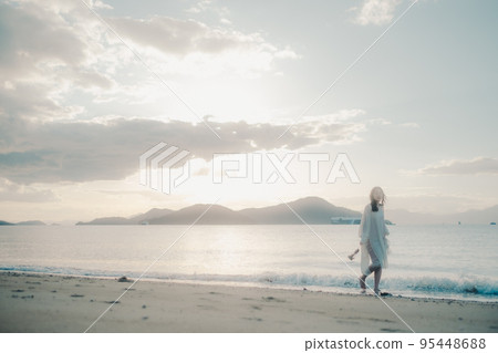 Photo of a woman standing by the beach 95448688