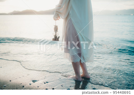 Photo of a woman standing by the beach Photo of a woman standing by the beach 95448691
