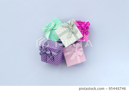 Pile of a small colored gift boxes with ribbons lies on a violet background 95448746