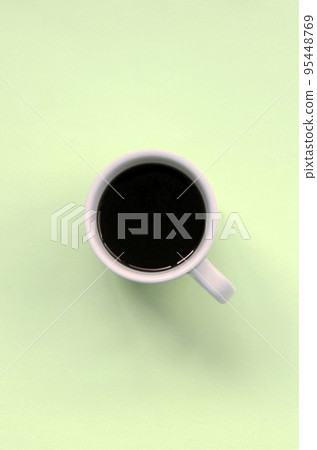 Small white coffee cup on texture background of fashion pastel lime color paper Small white coffee cup on texture background of fashion pastel lime color paper 95448769