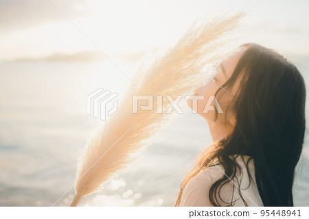 Photo of a woman standing by the beach 95448941
