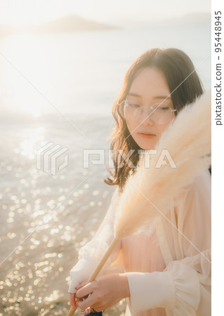 Photo of a woman standing by the beach 95448945